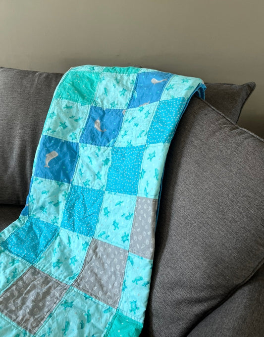 a blue patchwork quilt draped over a chair.